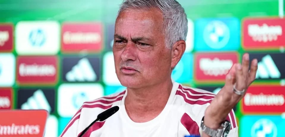 Entrenador en conferencia de prensa con logotipos de patrocinadores
