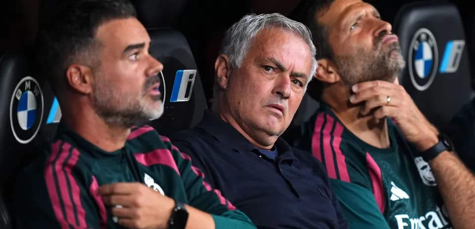 Entrenadores sentados en el banquillo durante el partido