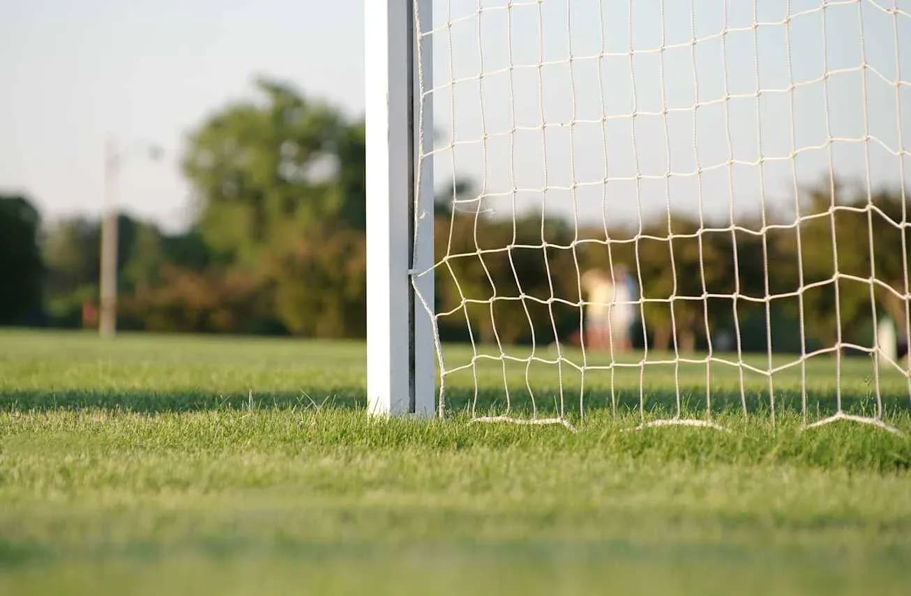 Portería de fútbol en campo verde con fondo difuso