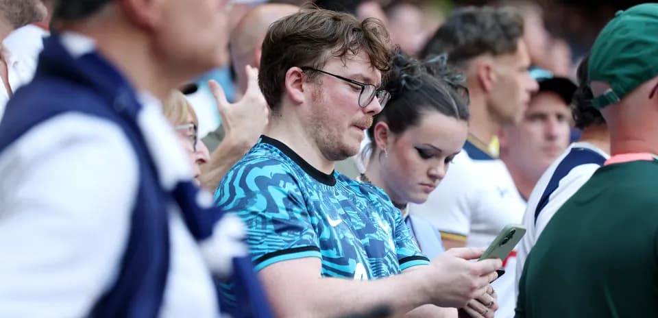 A group of fans watching the match attentively
