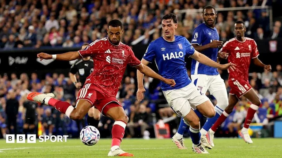 Jugador de Liverpool disparando mientras es defendido