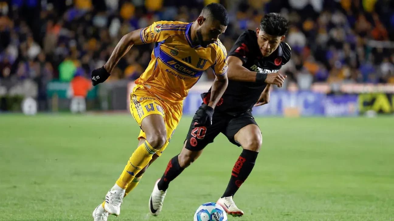 Jugador de Tigres UANL desafiando a un jugador de Toluca