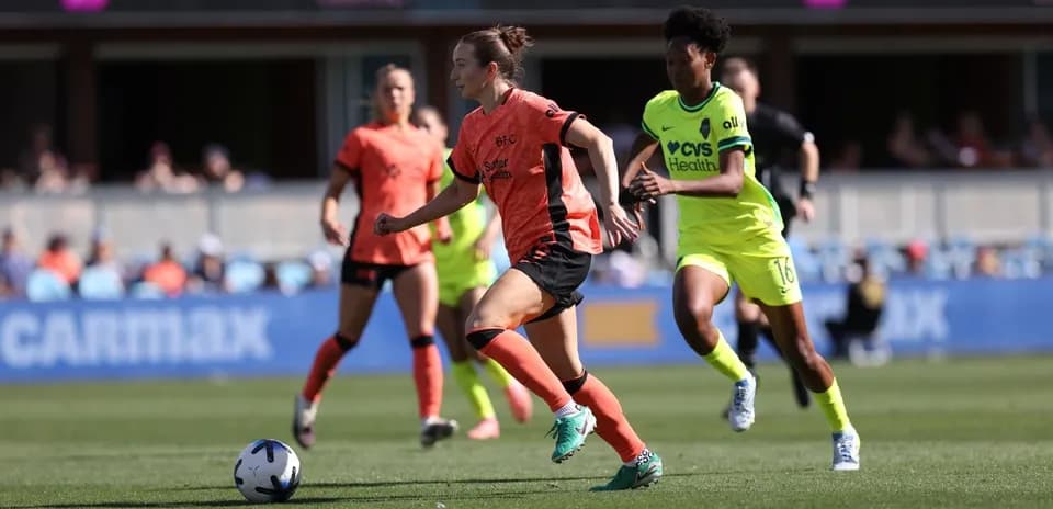 Jugadora de Bay FC corriendo con el balón