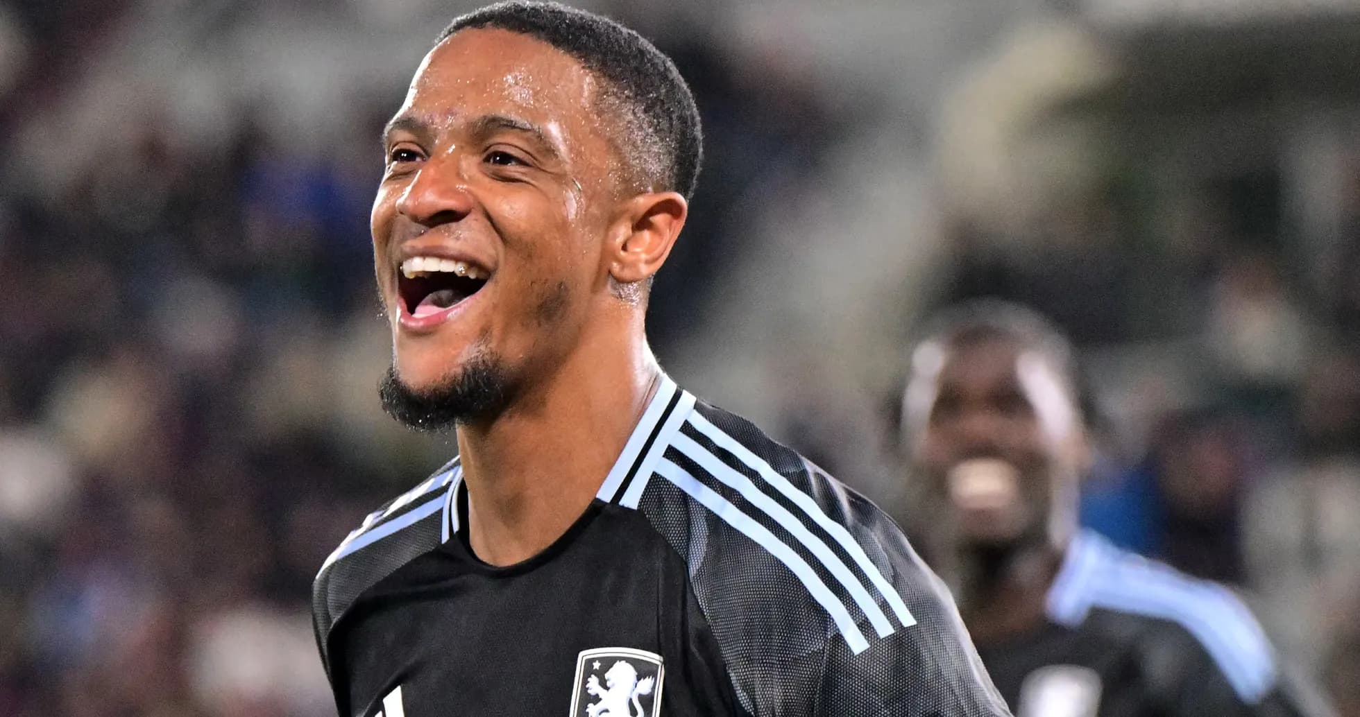 Jugador sonriente en uniforme de fútbol durante partido