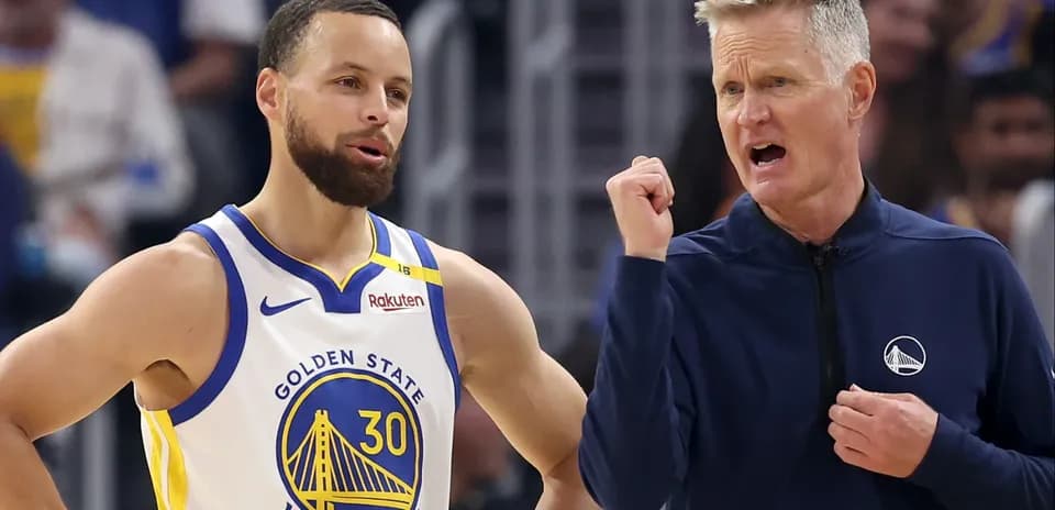 Stephen Curry conversando con el entrenador Steve Kerr