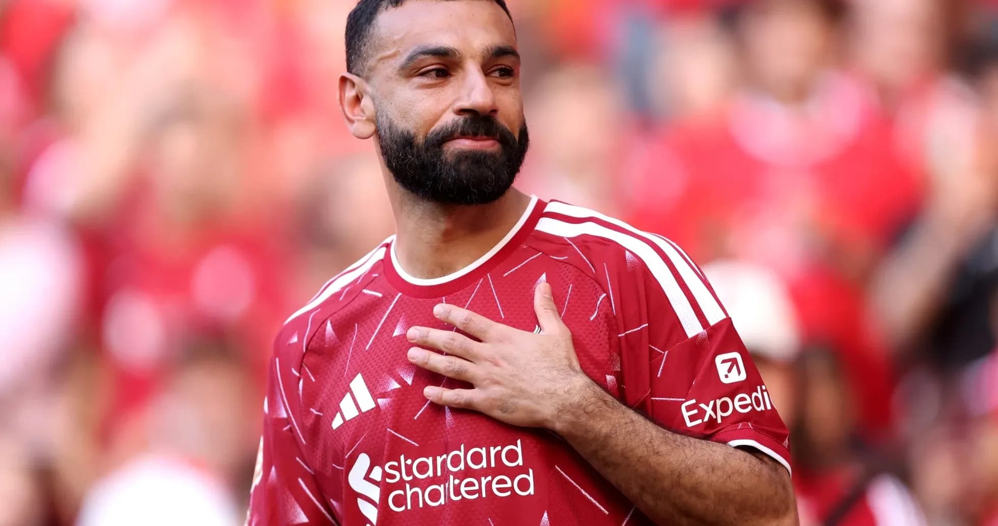 Jugador con camiseta roja saludando a la afición