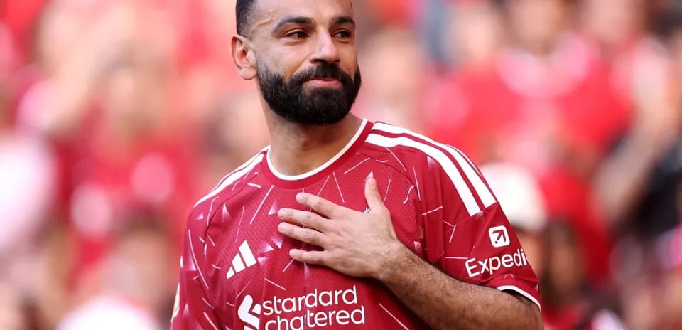 Jugador con camiseta roja saludando a la afición