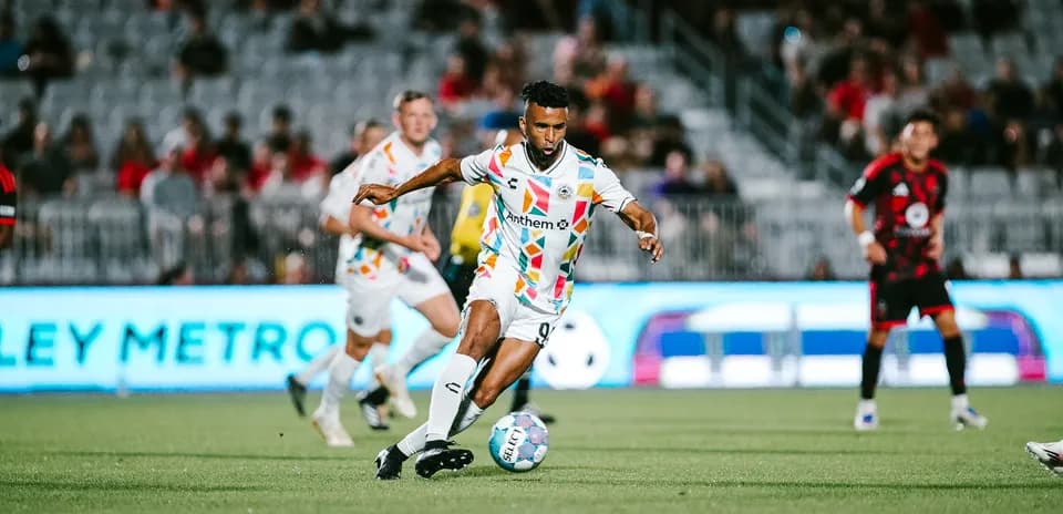 Jugador driblando en partido de fútbol
