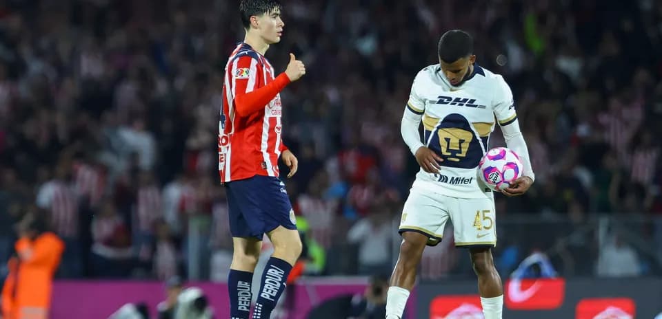 Jugadores de Chivas y Pumas en el campo