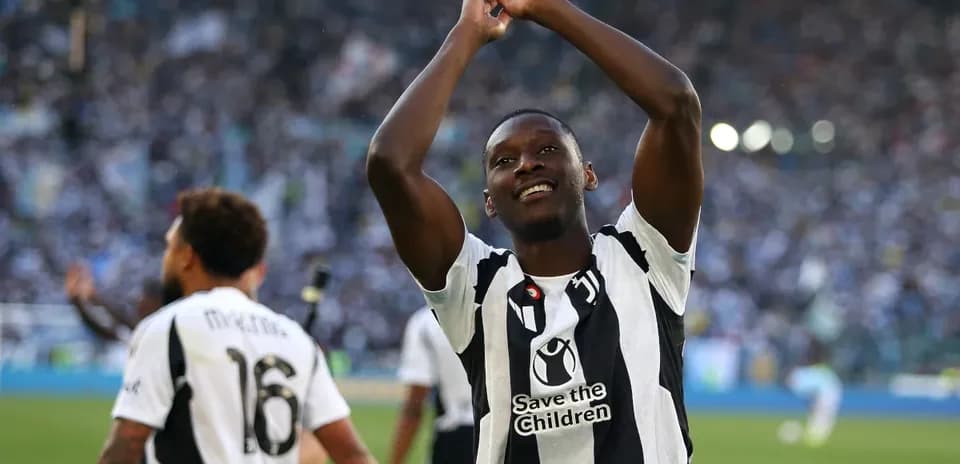 Jugador celebrando en el campo con afición al fondo