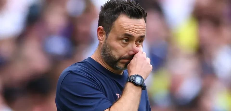 Entrenador pensativo en el banquillo durante el partido