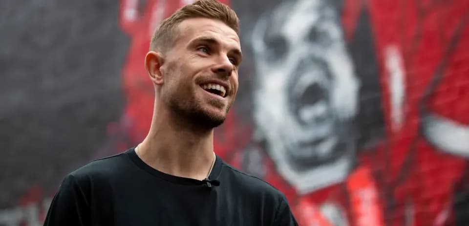 Jugador sonriendo frente a un mural en la pared