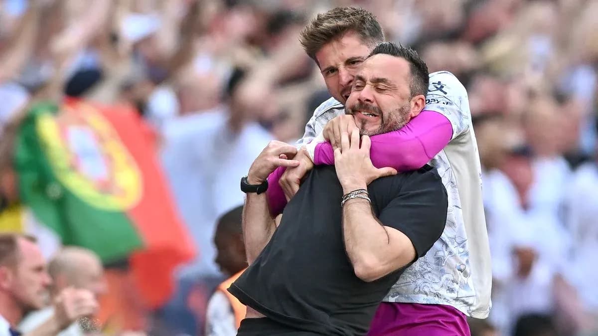 Entrenadores celebrando con un abrazo en el estadio