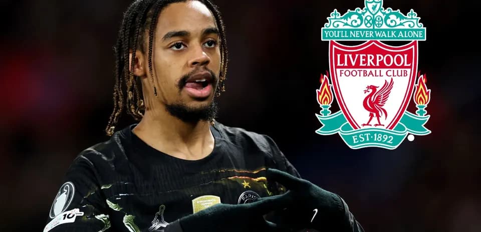 Jugador señalando el escudo de Liverpool FC