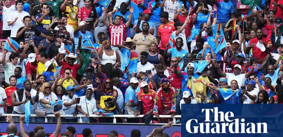 Aficionados animando con banderas en estadio