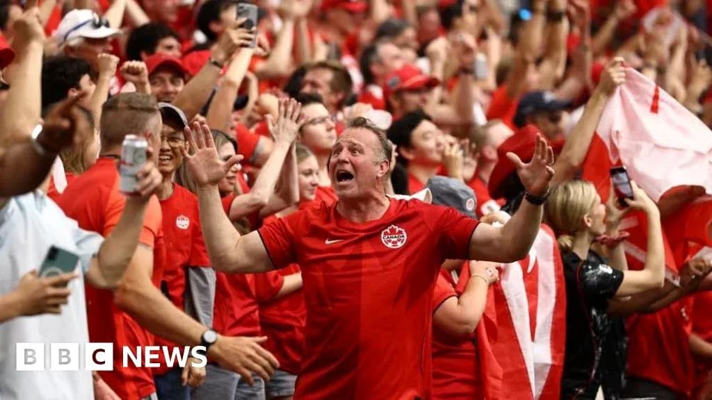 Aficionados animando con camisetas rojas en estadio