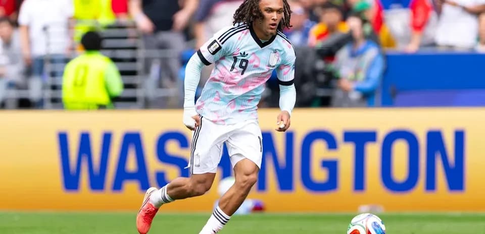 Jugador corriendo con balón en el campo de fútbol