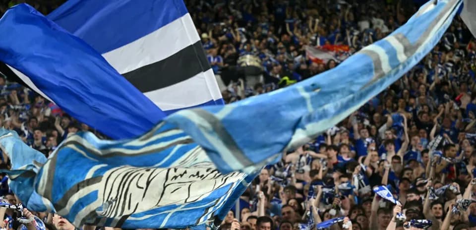 Aficionados ondeando banderas y bufandas en el estadio