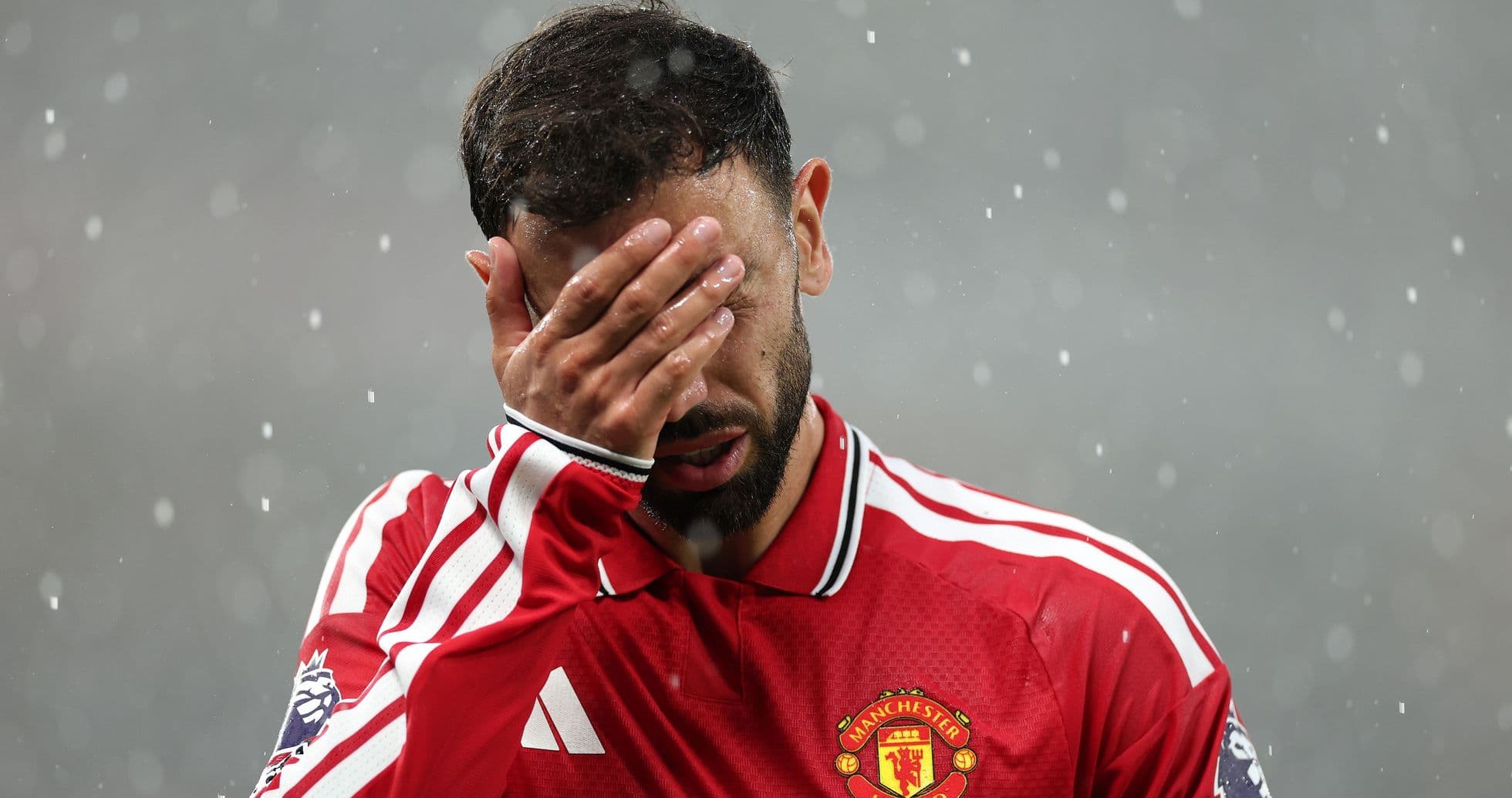 Jugador de Manchester United cubriendo su cara con la mano