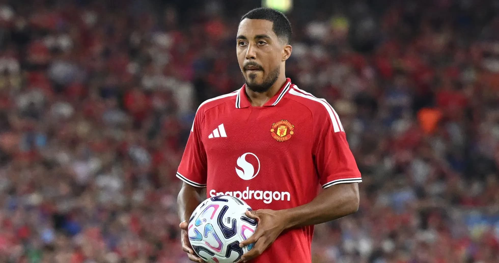 Jugador de Manchester United sosteniendo un balón en el campo