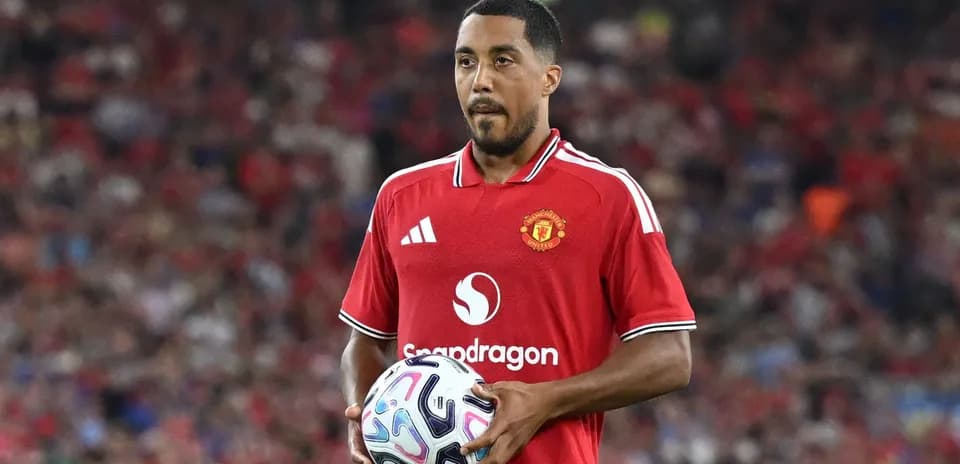 Jugador de Manchester United sosteniendo un balón en el campo