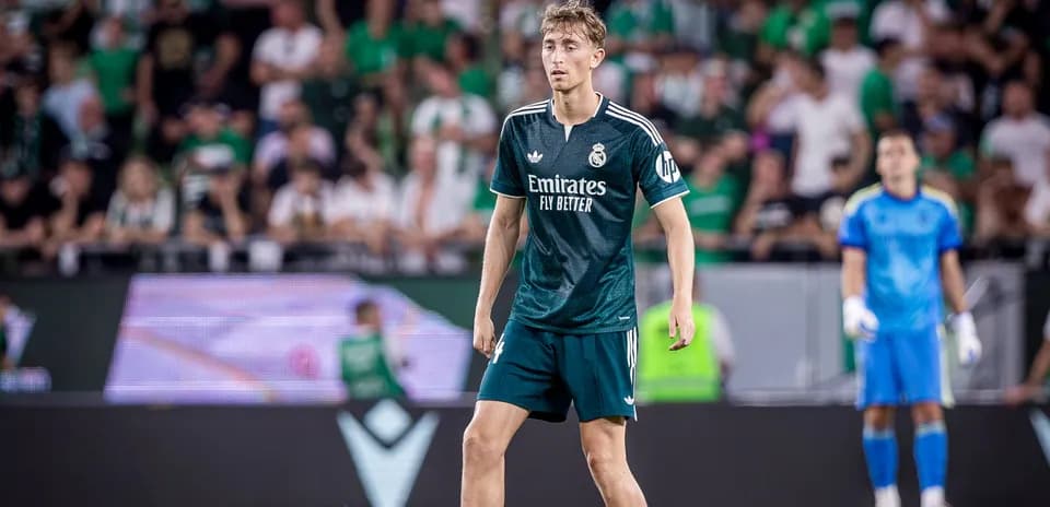 Jugador de Real Madrid en partido con aficionados al fondo
