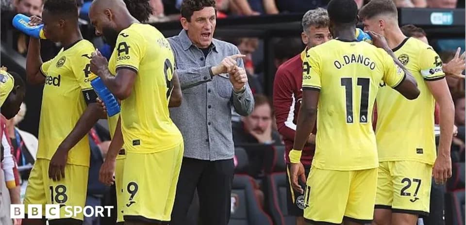 Entrenador dando instrucciones a jugadores en banquillo