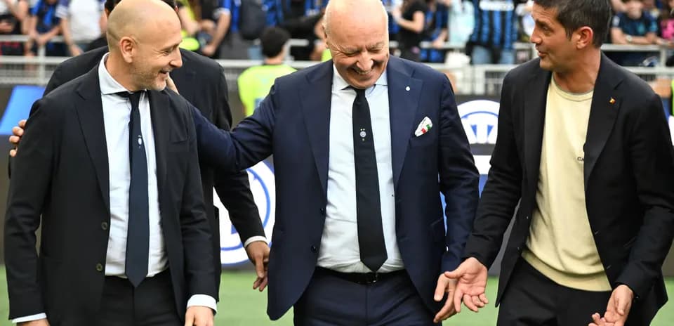 Tres entrenadores conversando en el campo de fútbol