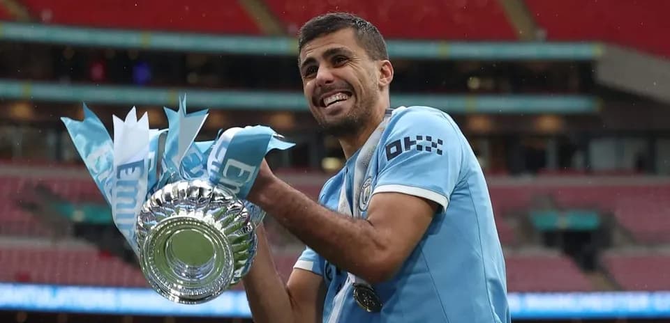 Jugador de Manchester City sosteniendo el trofeo