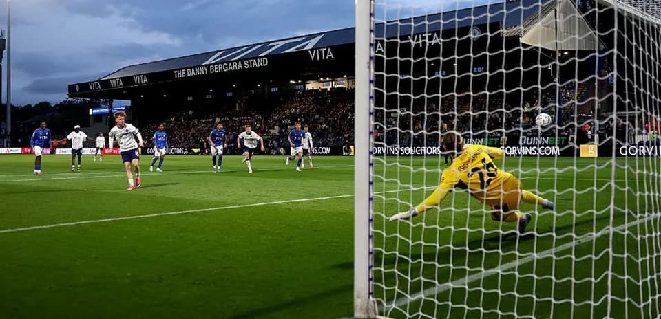 Jugador lanzando penalti mientras portero se lanza