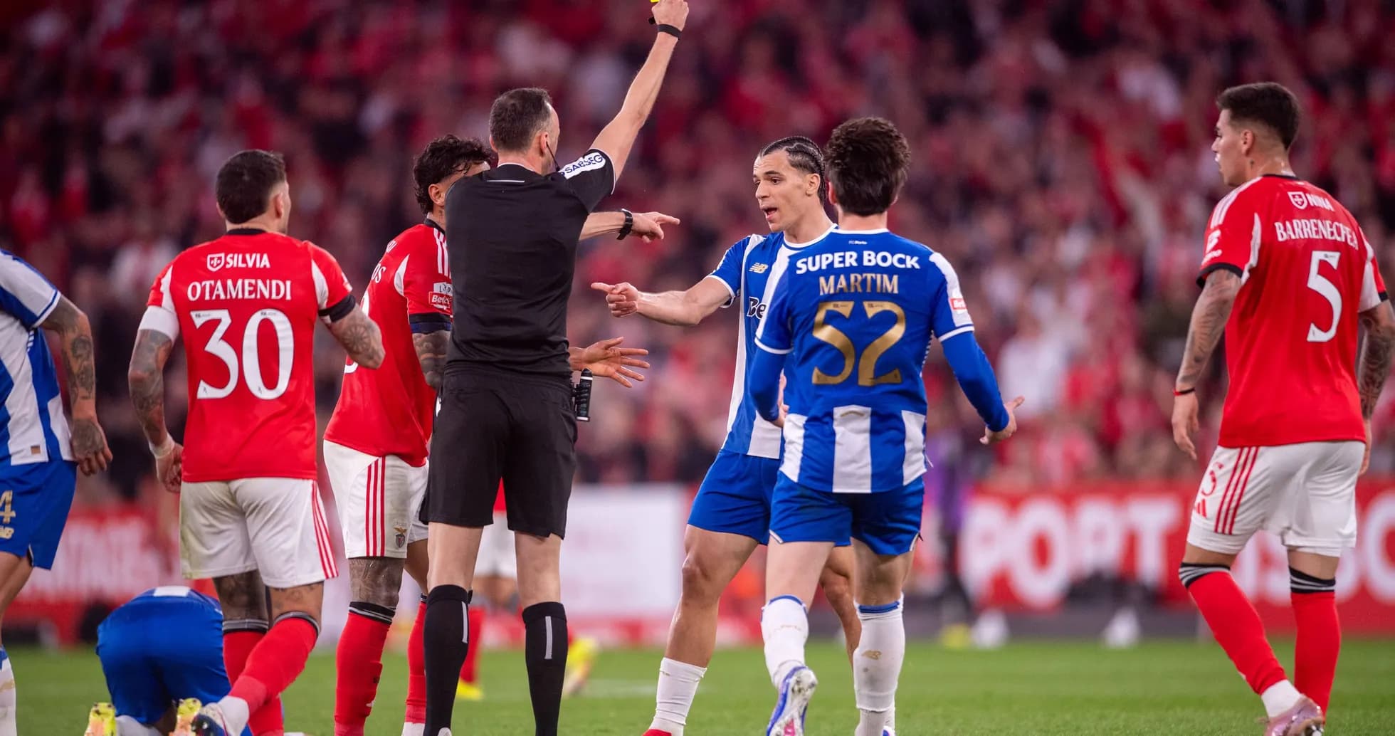 Árbitro mostrando tarjeta amarilla durante partido