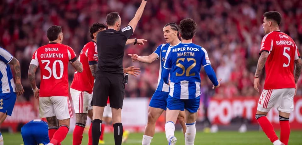 Árbitro mostrando tarjeta amarilla durante partido