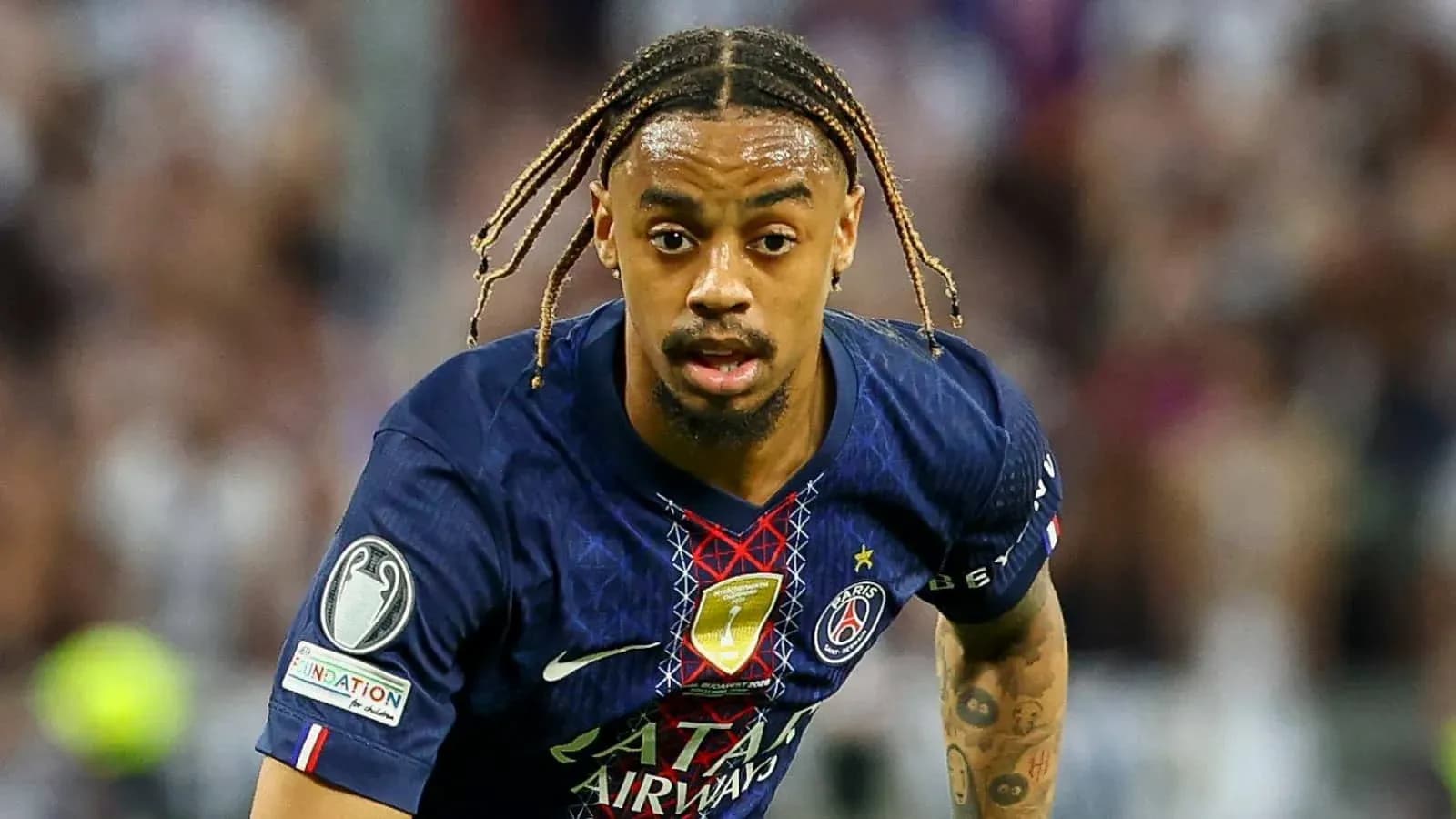 Jugador de PSG corriendo con balón en el campo