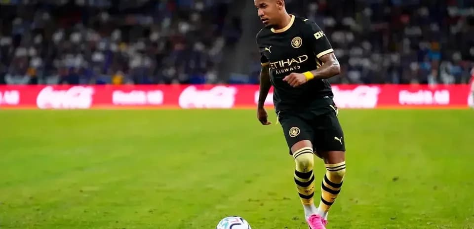 Jugador corriendo con balón en el campo de fútbol
