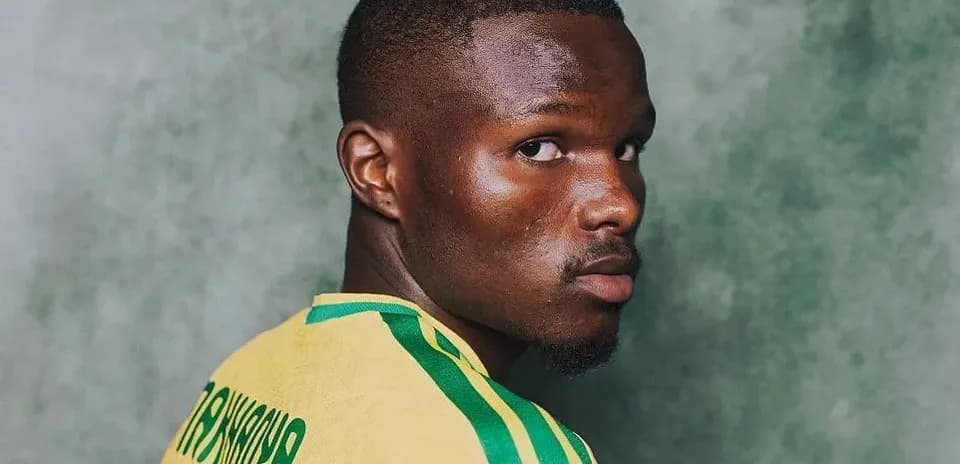 Jugador de fútbol con camiseta amarilla y verde