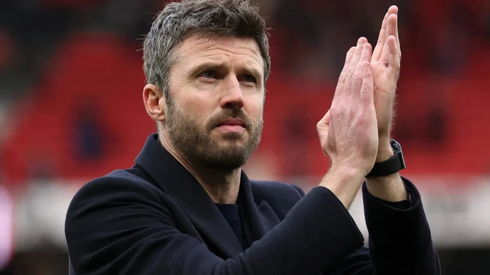 Entrenador aplaudiendo a los aficionados en el estadio