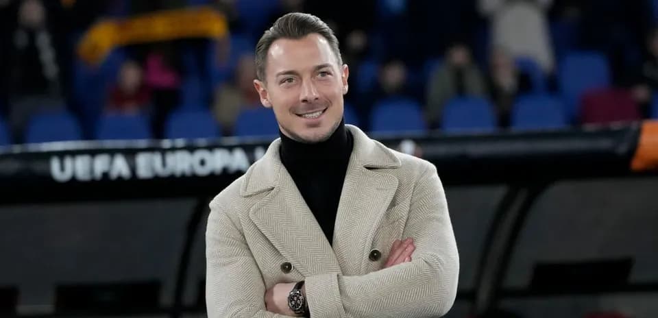 Hombre sonriente con abrigo en el banquillo