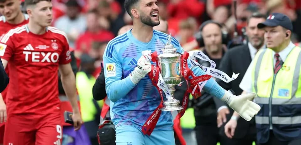 Portero sosteniendo el trofeo después del partido