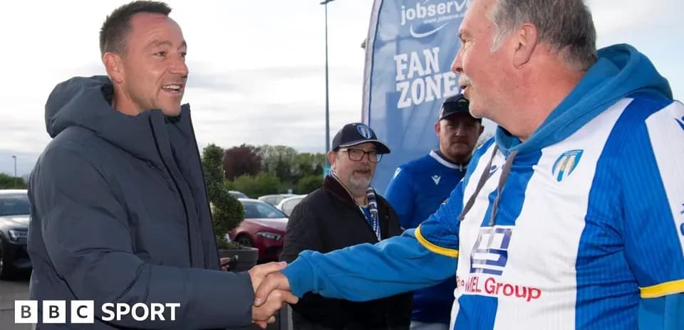 Hombre saludando a aficionado en zona de aficionados