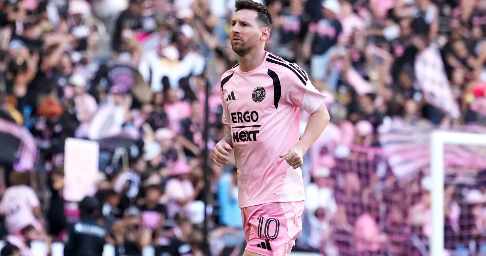 Lionel Messi corriendo en el estadio con afición