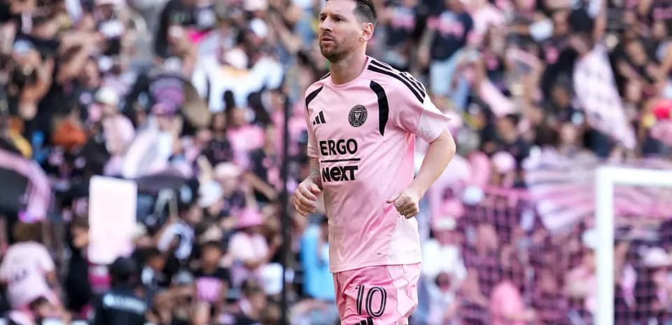 Lionel Messi corriendo en el estadio con afición