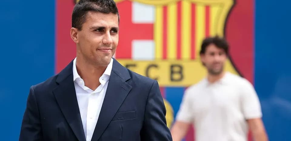 Jugador posando frente al escudo del FC Barcelona