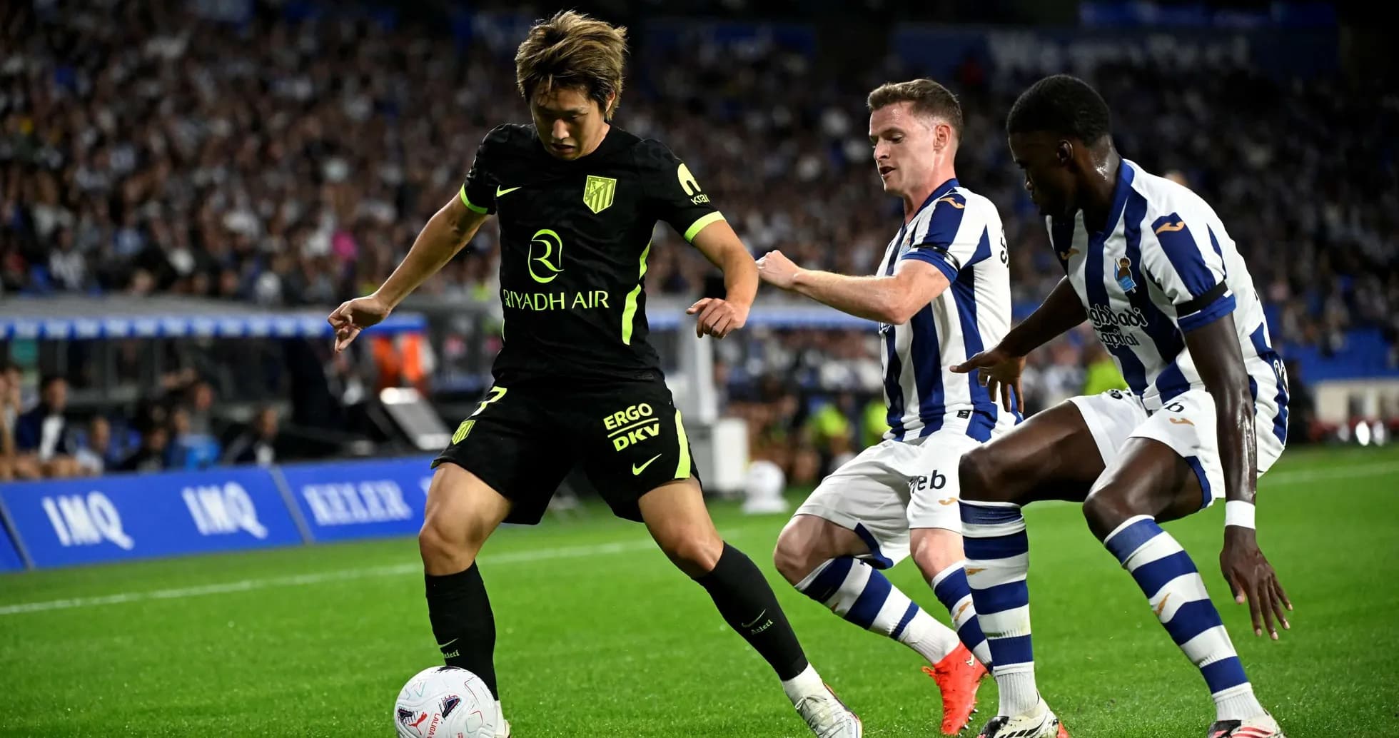 Jugadores de Real Sociedad y Atlético de Madrid compitiendo