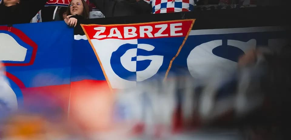 Aficionados sosteniendo la bandera de Górnik Zabrze