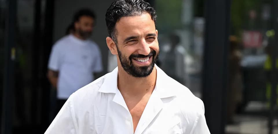 Hombre sonriendo con camisa blanca en la calle