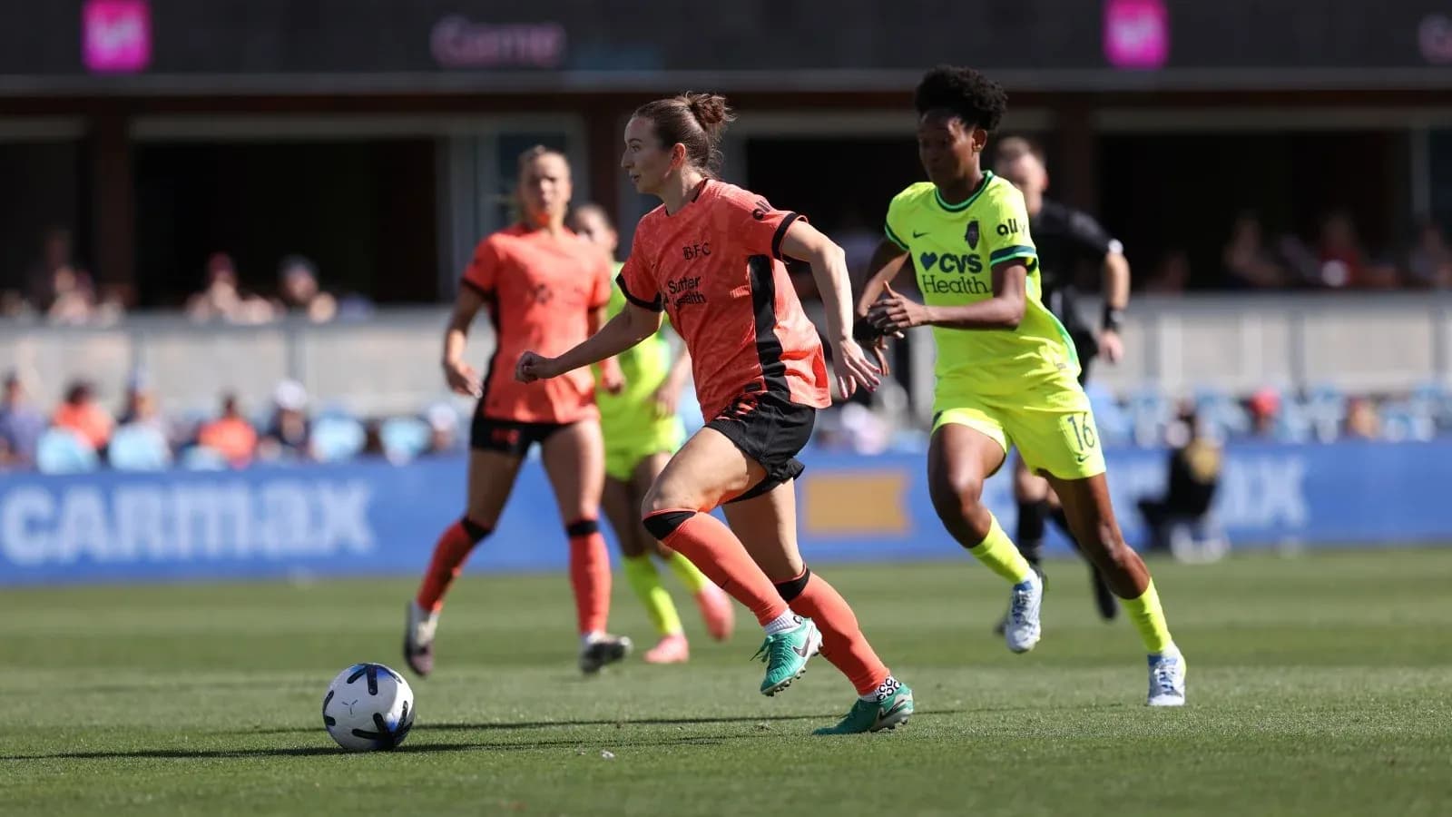 Jugadora de Bay FC corriendo con el balón