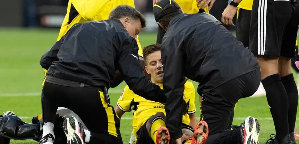 Jugadores de Borussia Dortmund reciben atención médica en el campo