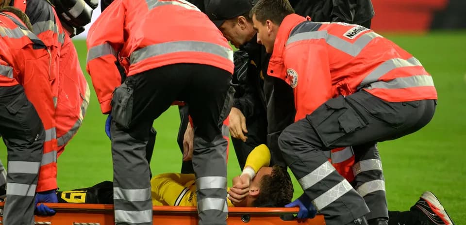 Equipo médico atendiendo a jugador lesionado en el campo