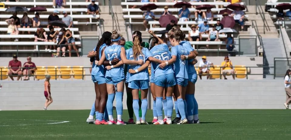Equipo de fútbol femenino en círculo antes del partido