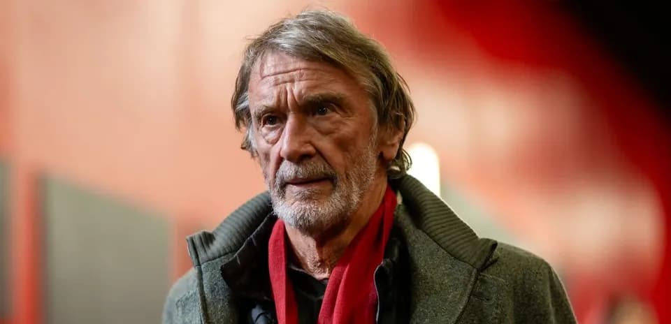 Hombre con abrigo y bufanda roja en un pasillo